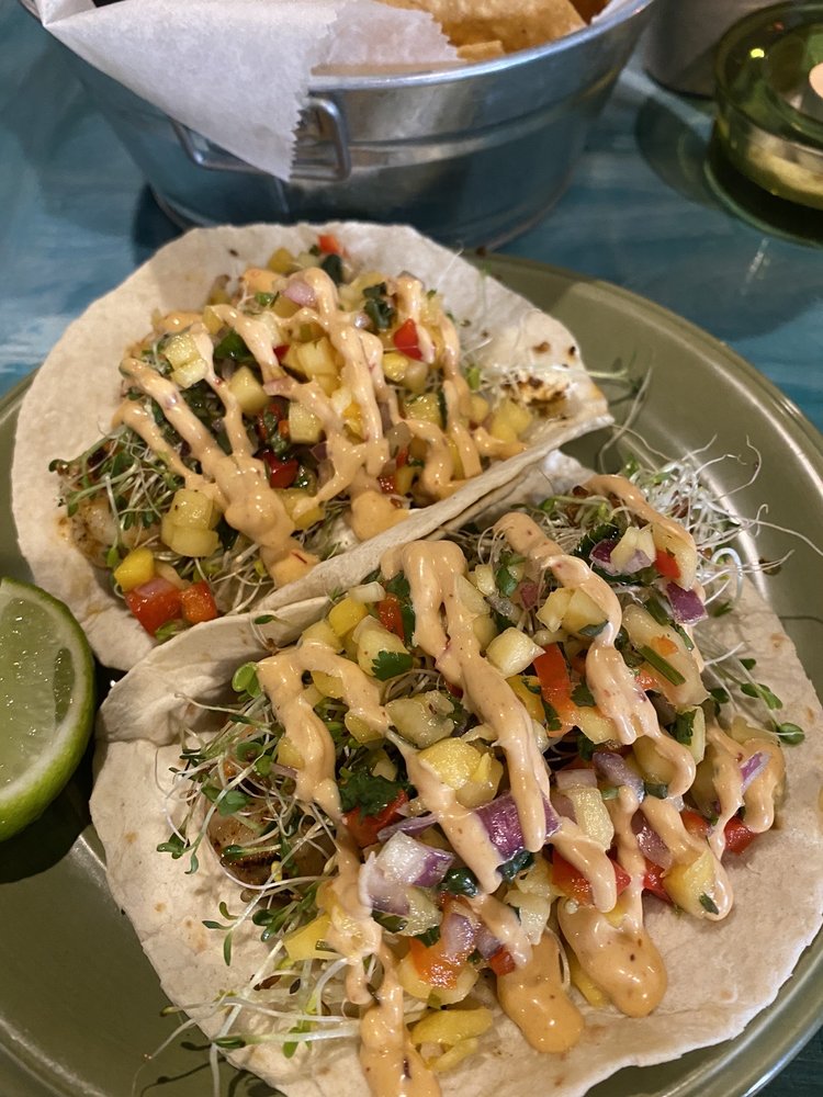 A plate of tacos with a lime wedge