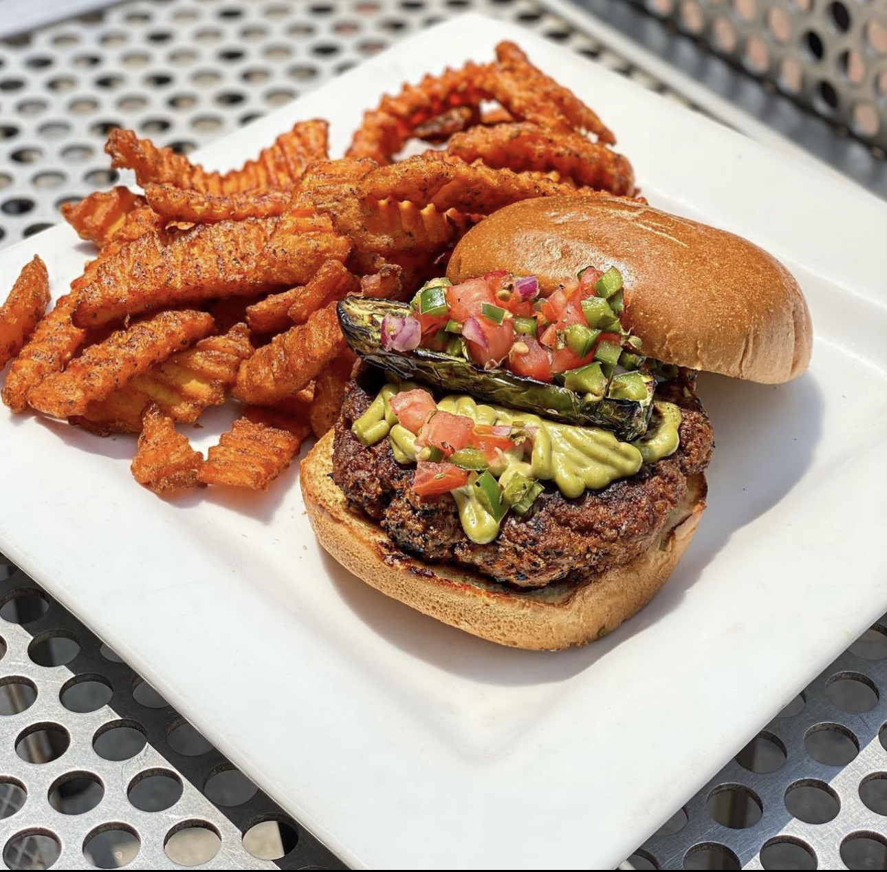 A burger with crinkle cut fries