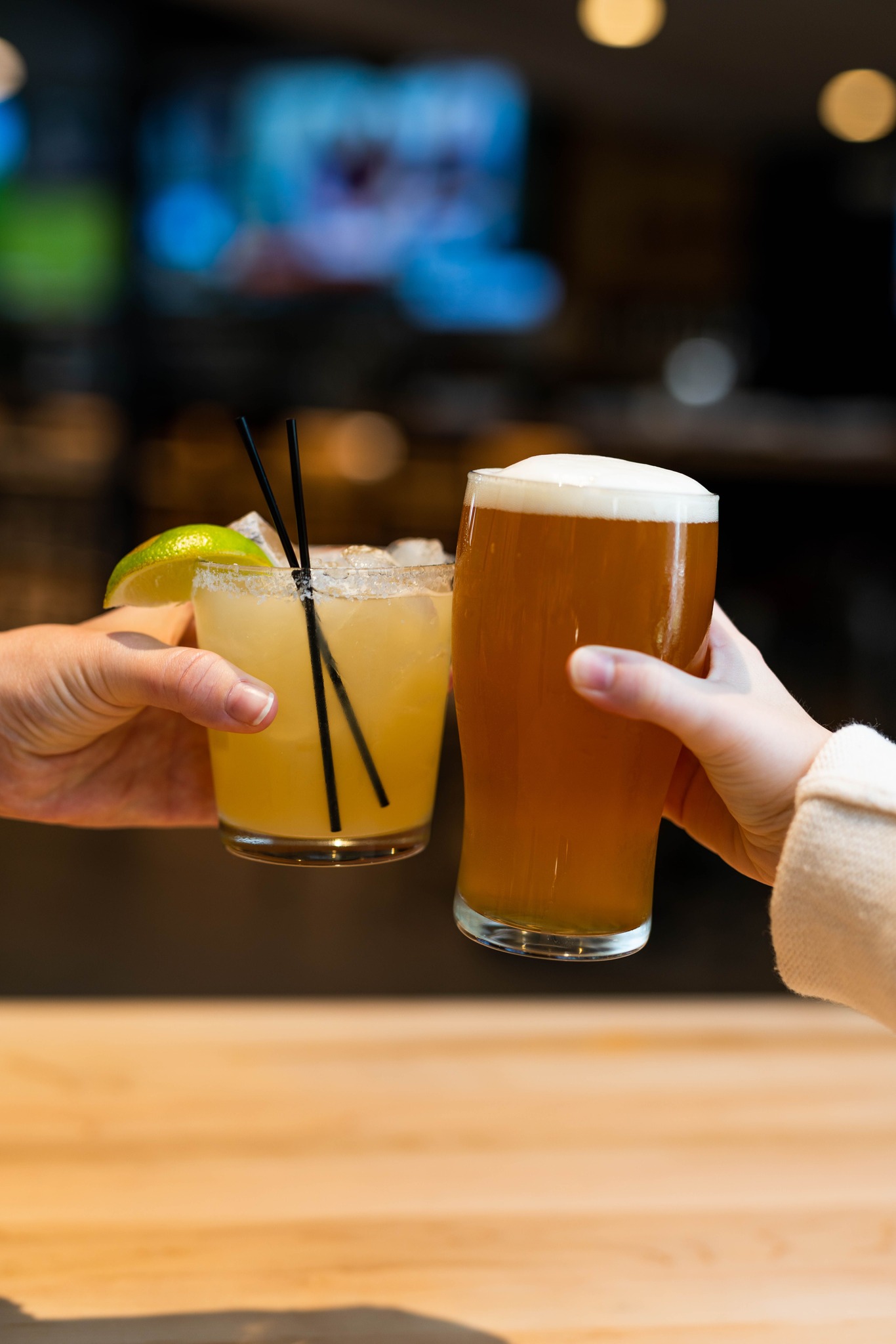 two hands holding drinks