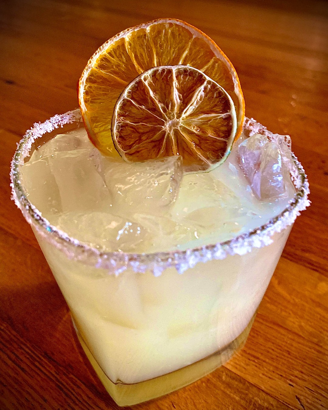 an Escalade Margarita with two dried orange wheels and a salt rim