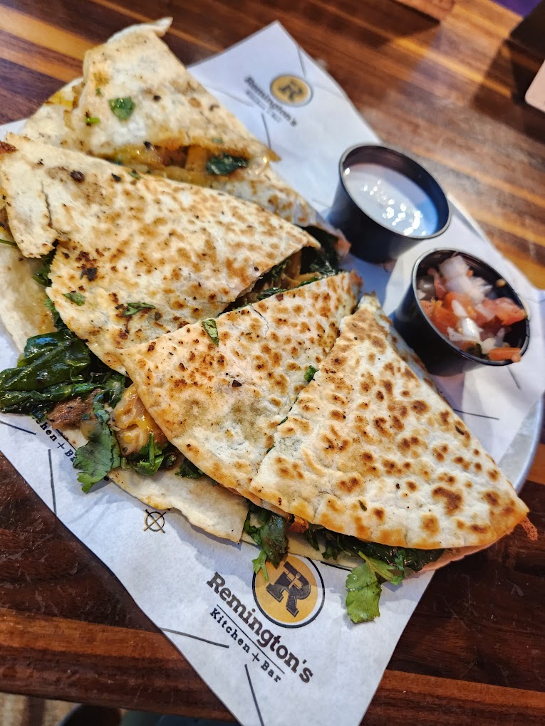 a quesadilla with sour cream and pico de gallo