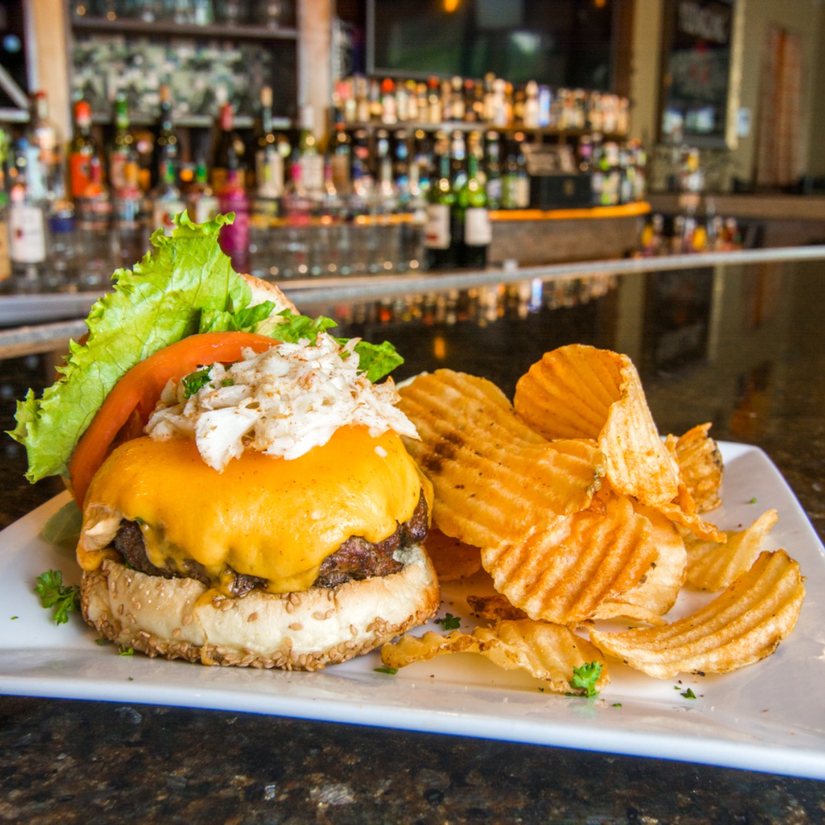 A cheeseburger and potato chips on a plate