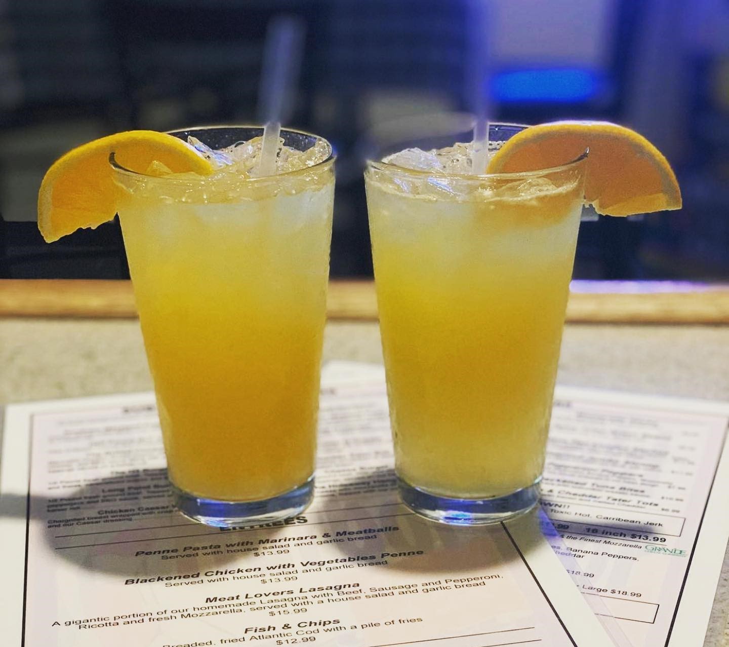 two orange crushes with orange wedges