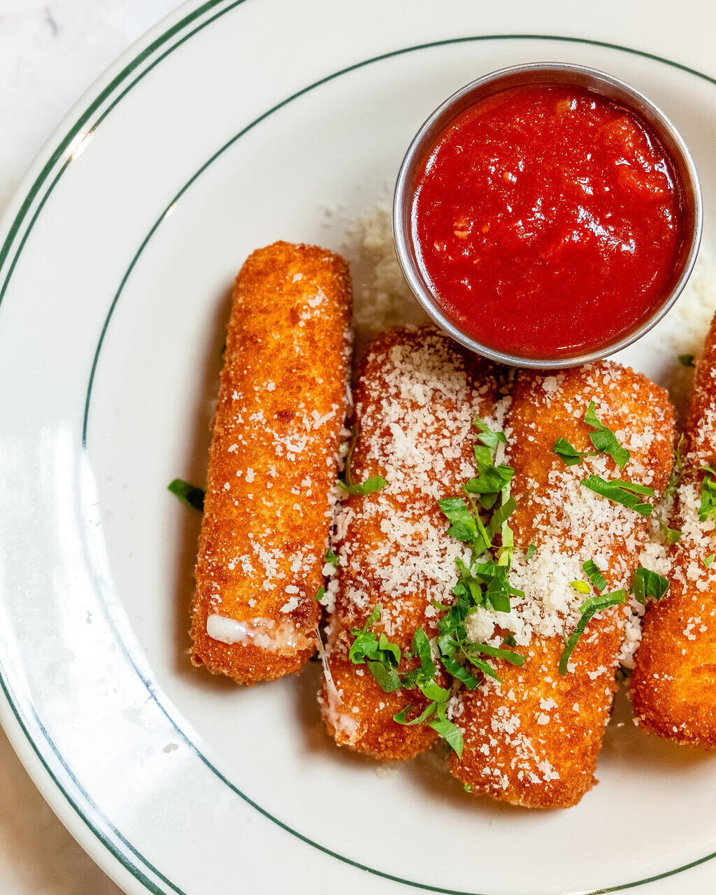 a plate of mozzarella sticks and marinara sauce