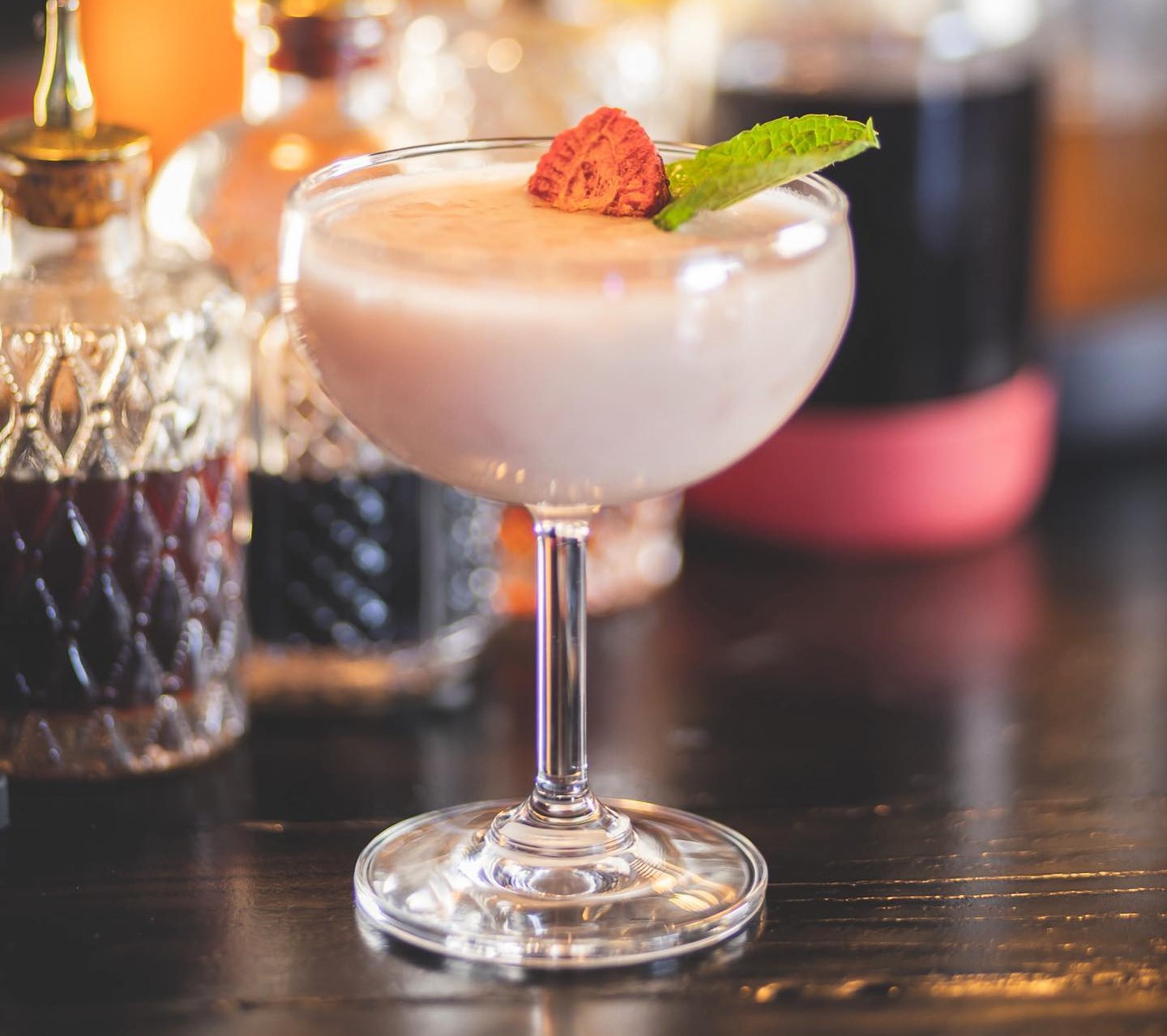 a "Strawberry Fields" cocktail with a strawberry and a mint leaf