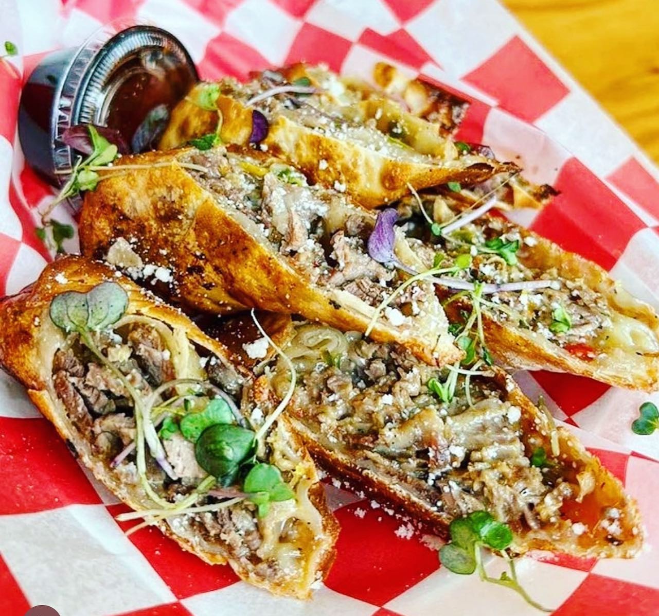 a plate of cheesesteak egg rolls from Cheezy Mike's