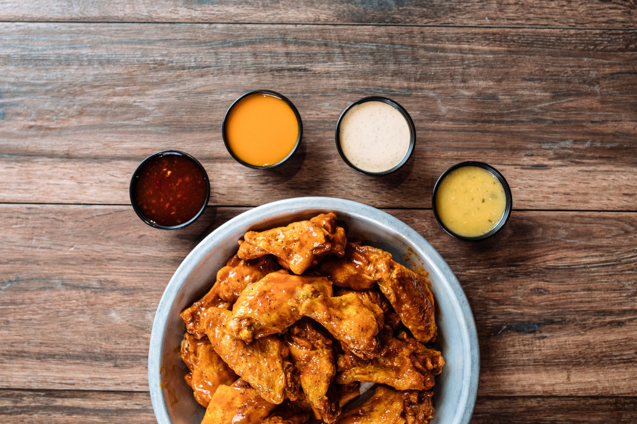 a plate of wings with four dips