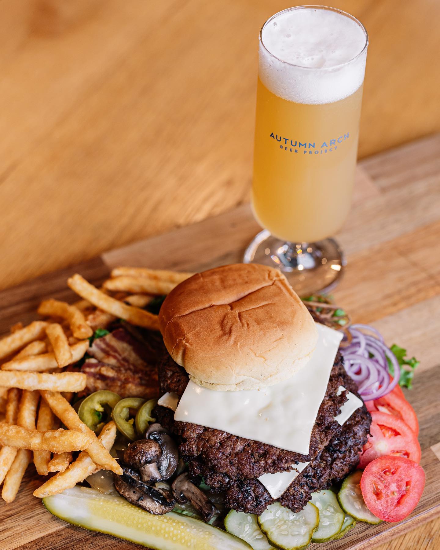 a burger with fries and a glass of beer