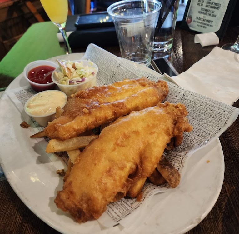 a plate of fish and chips with dips