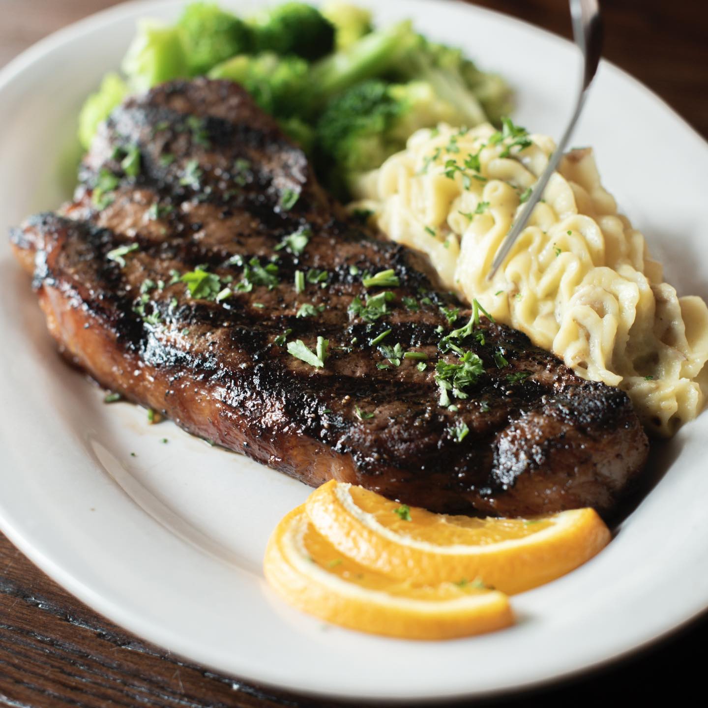 a steak with mashed potatoes and broccoli