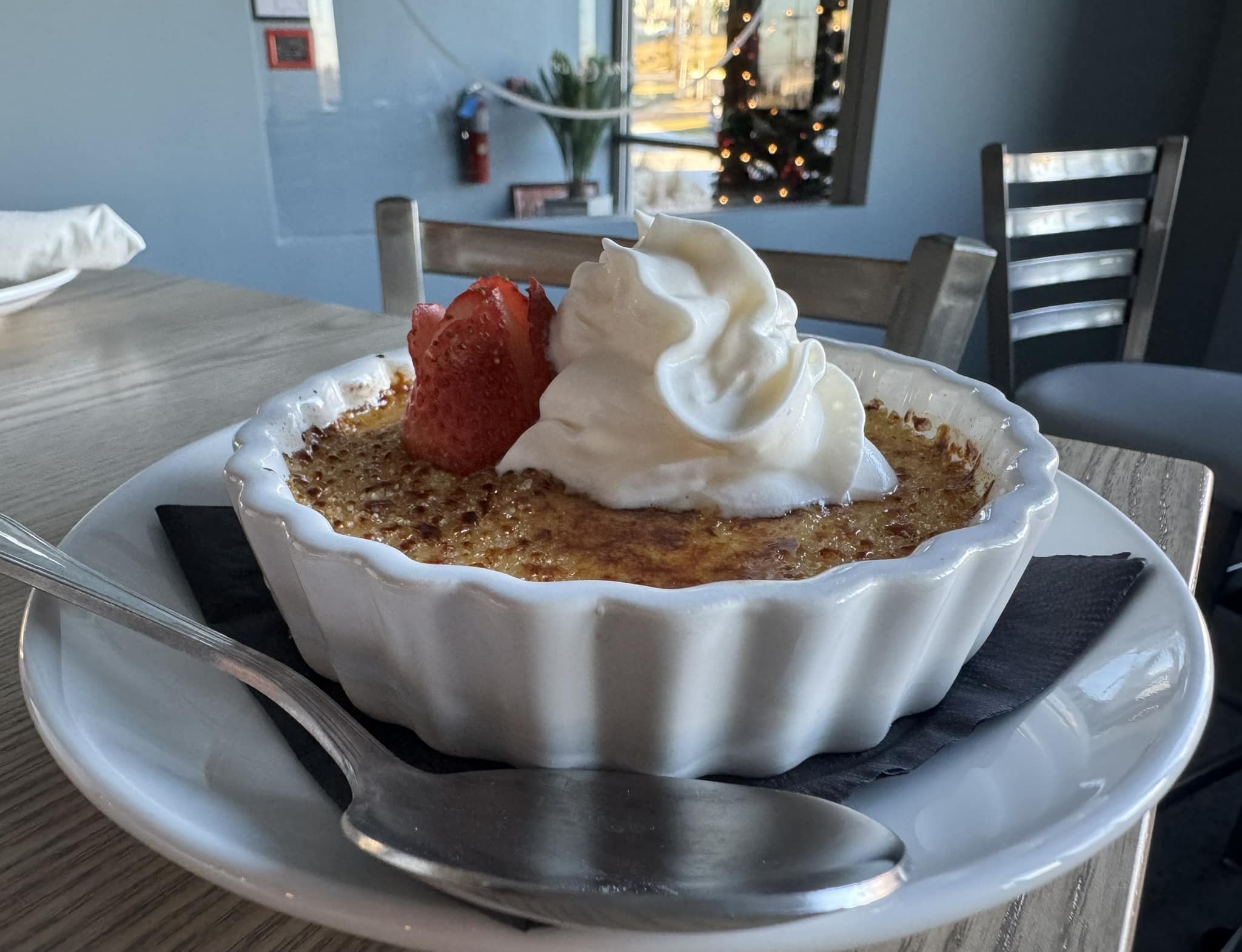 a creme brulee with whipped cream and a strawberry