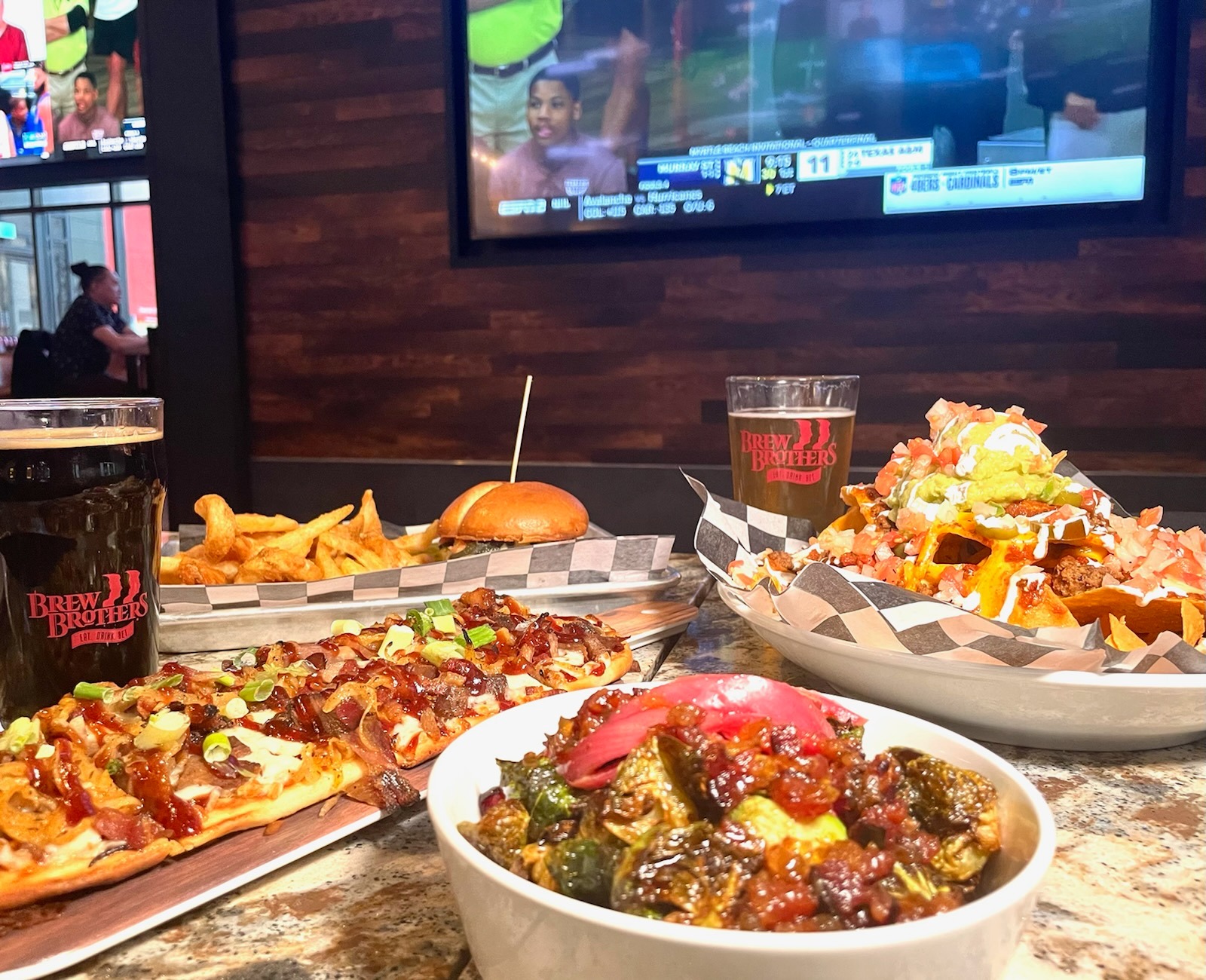 several plates of food, including nachos and a burger