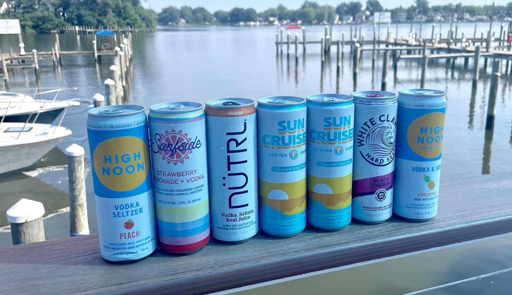 a row of hard seltzer on a railing looking out over the water