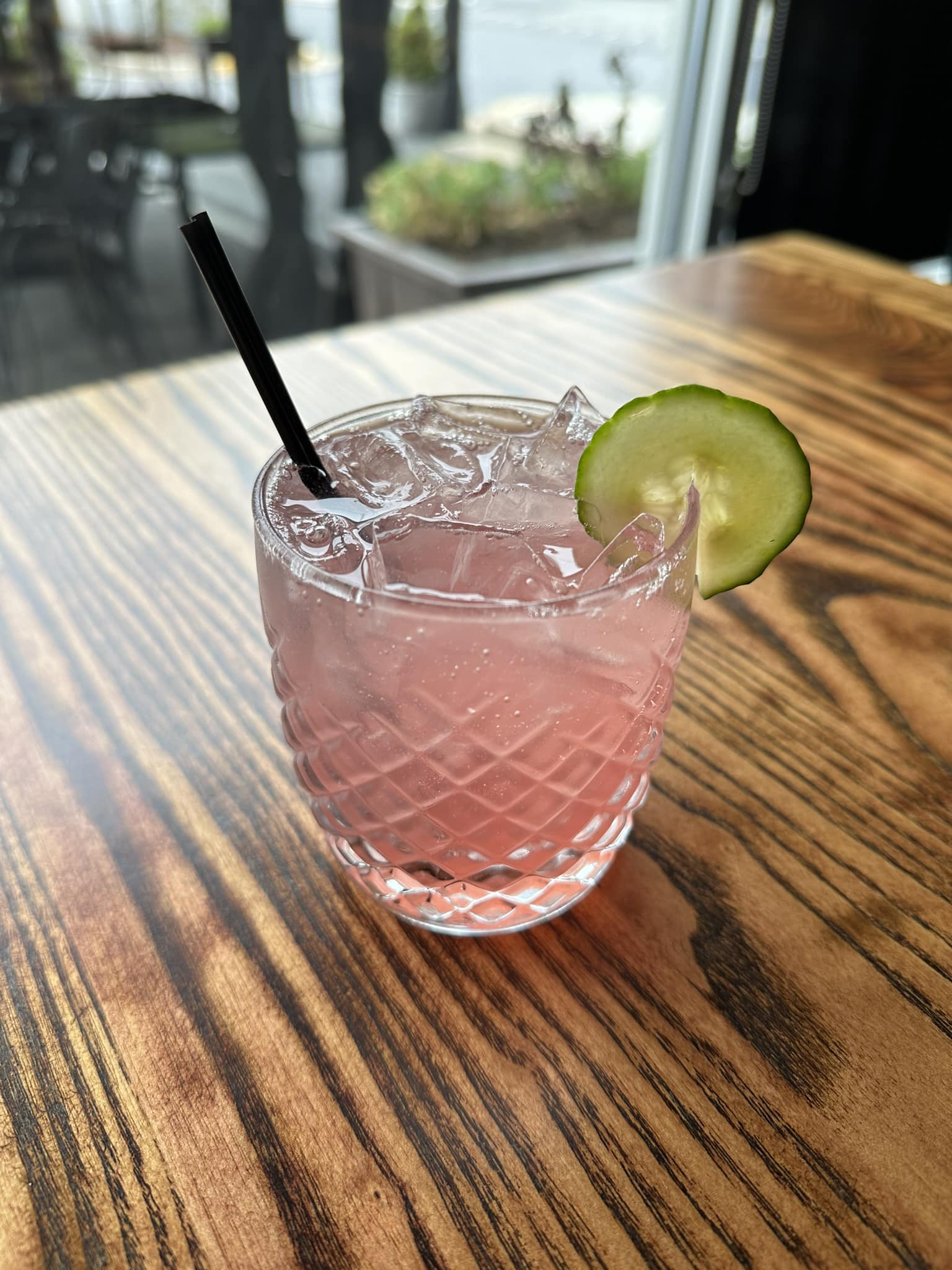 a Garden Berry cocktail with a cucumber slice