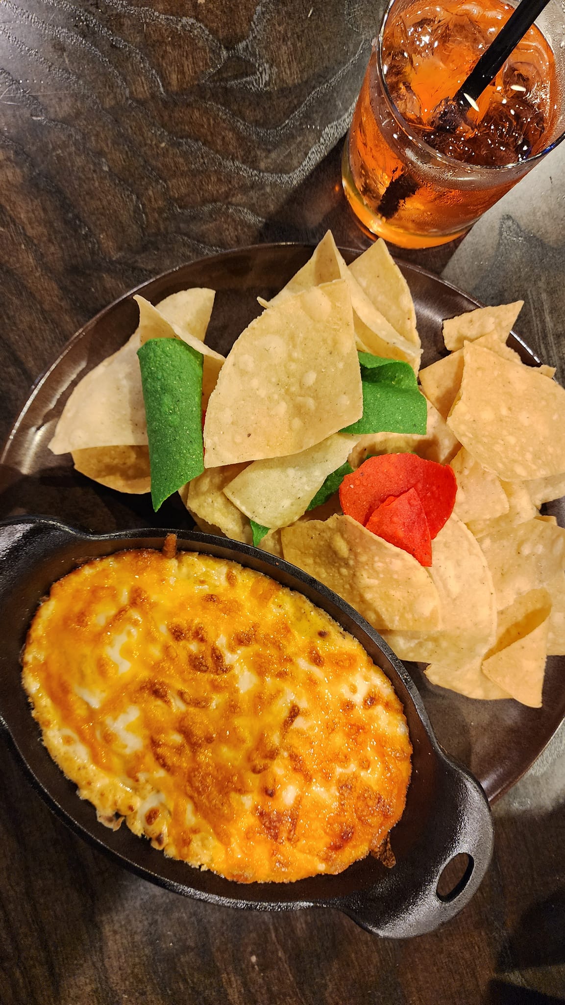 a Mexican Street Corn appetizer with tortilla chips and a drink