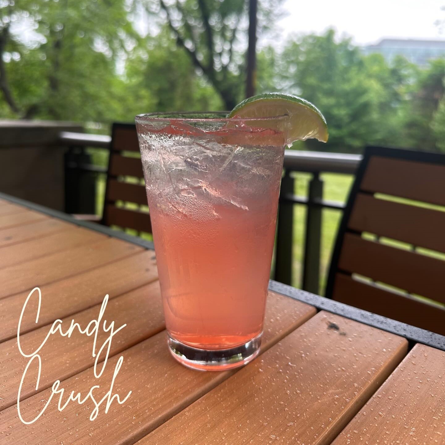 a pink cocktail with a lime wedge