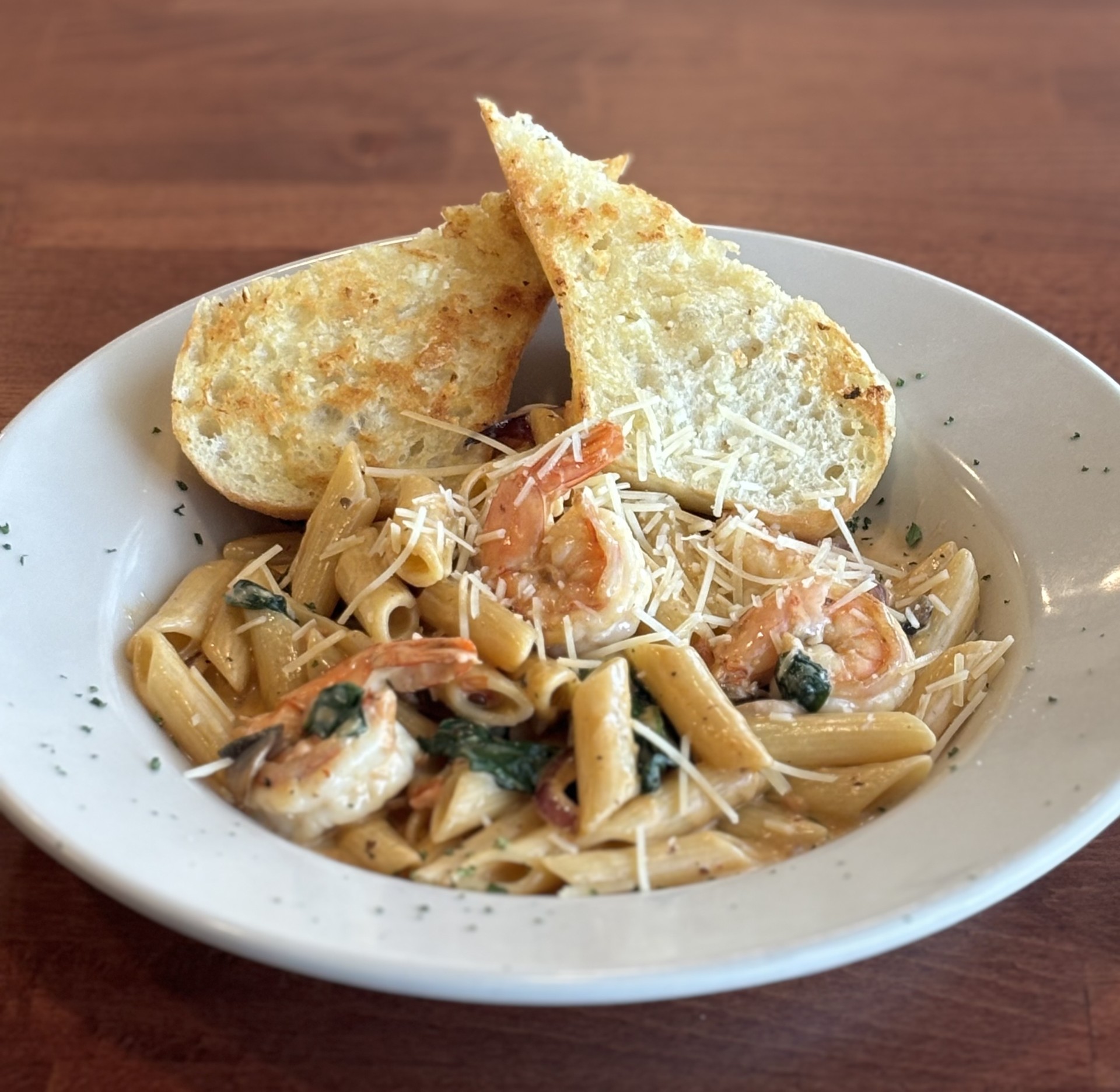 a plate of shrimp gregorio with two pieces of bread