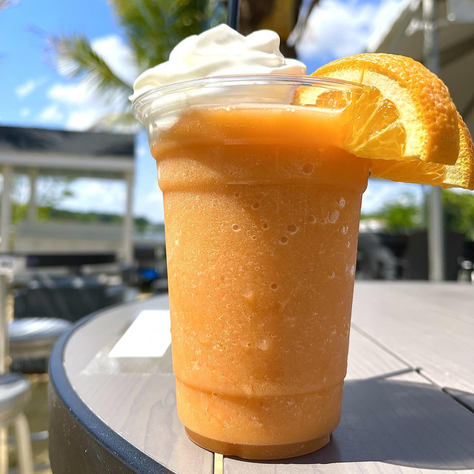 an Orange Creamsicle frozen cocktail with orange wedges and whipped cream