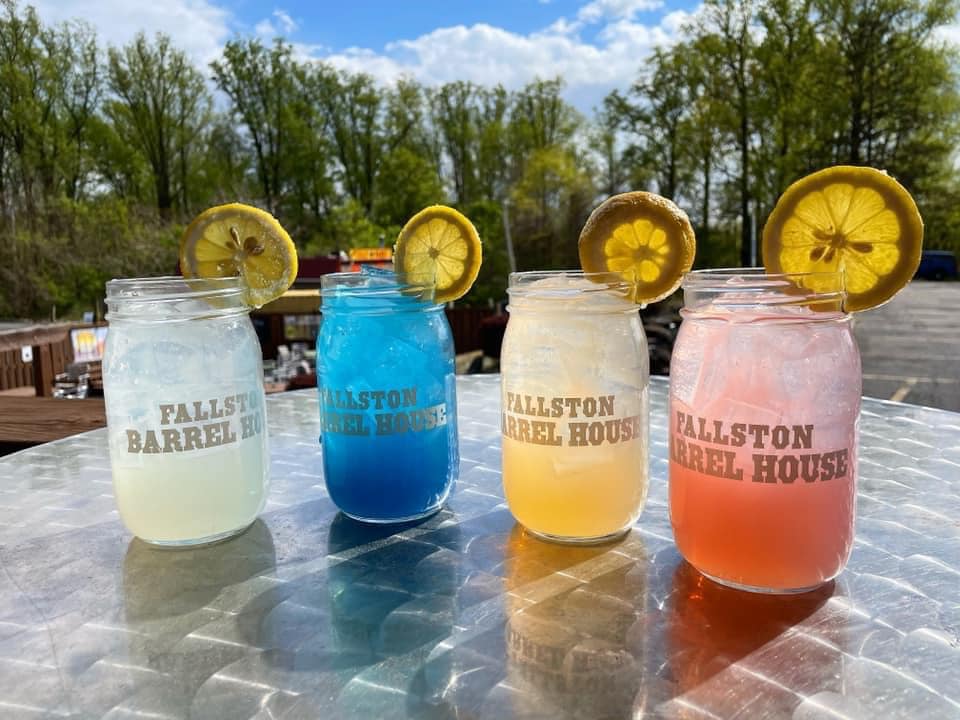 four colorful cocktails on a table, each has a lemon wheel