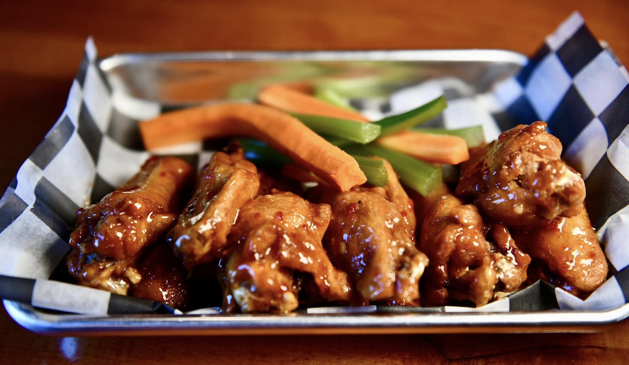 a tray of wings with carrots and celery