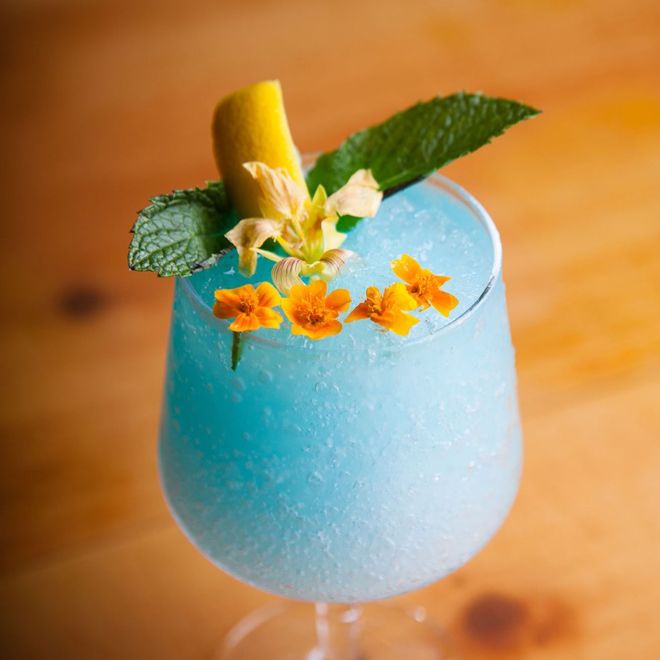 a blue cocktail with edible flowers