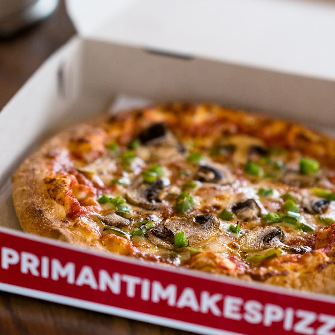 a pizza with mushrooms in a box