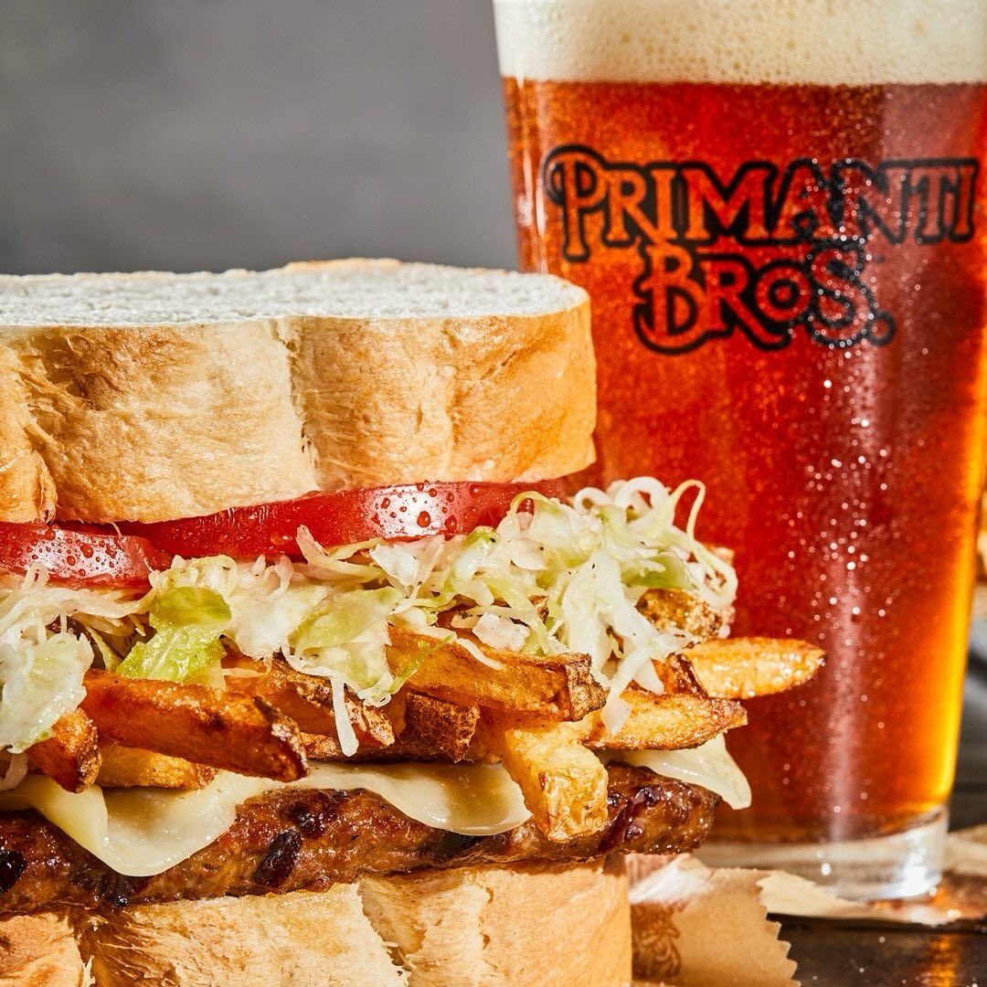 an almost famous sandwich with a glass of beer