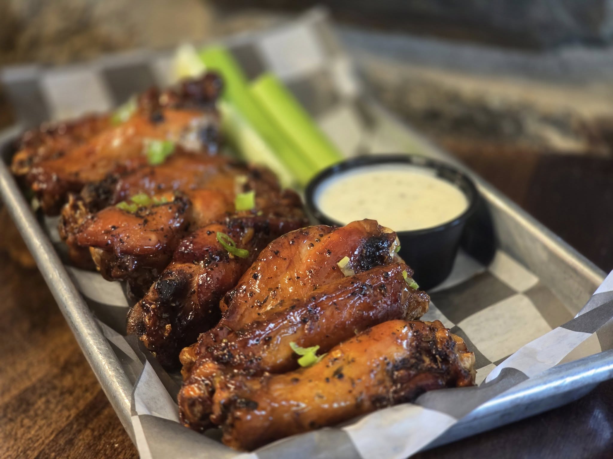 a plate of wings with celery and dip