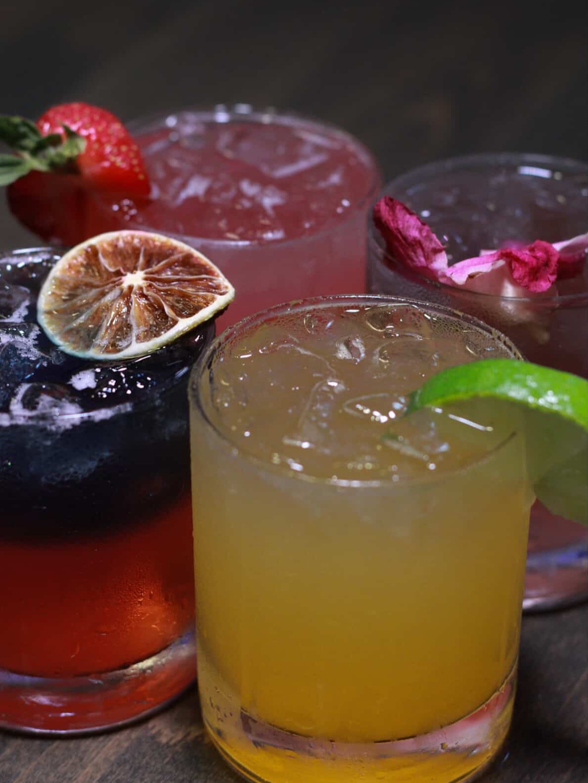 four colorful cocktails on a table